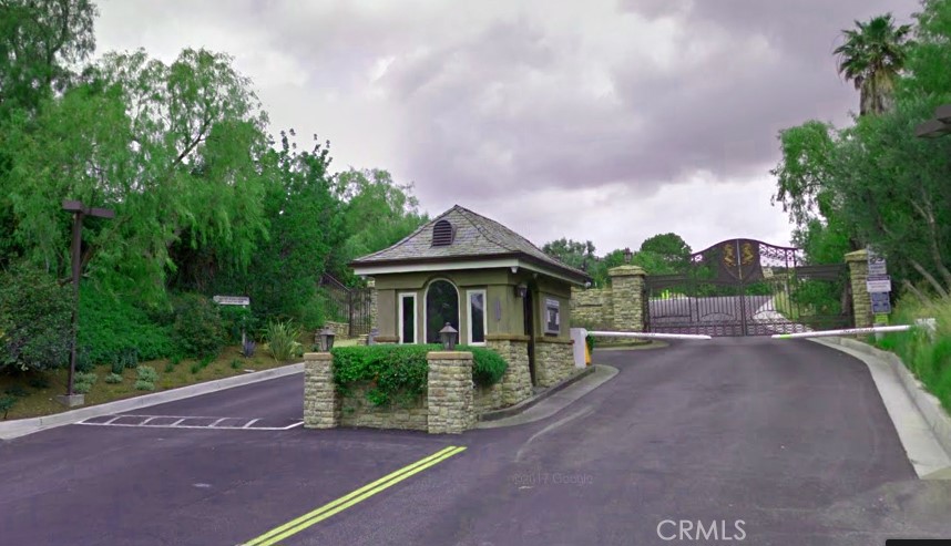 a view of a house with a yard and large trees