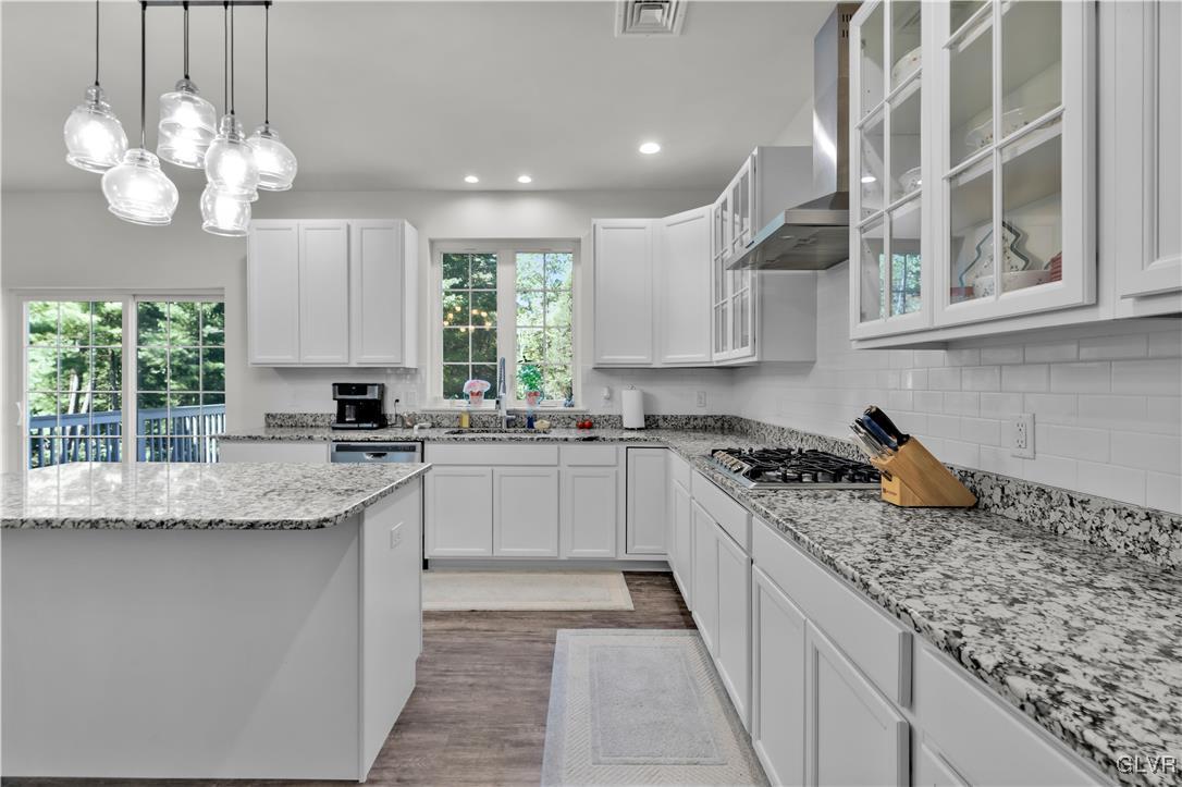 152 Corktree Road Kunkletown, PA 18058 - Photo 10 of 49 a kitchen with kitchen island granite countertop a stove a sink dishwasher and white cabinets with wooden floor