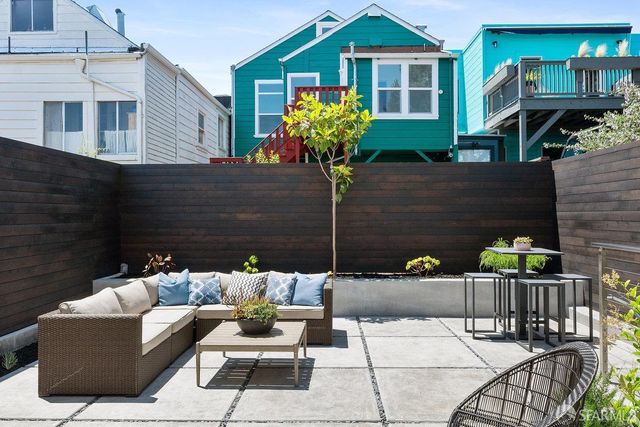 a view of a patio with couches table and chairs and potted plants