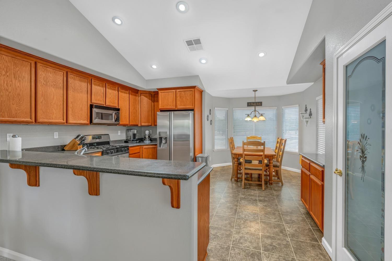 14155 Buchanan Hollow Road Le Grand, CA 95333 - Photo 28 of 46 a kitchen with stainless steel appliances granite countertop counter top space a sink a stove and furniture