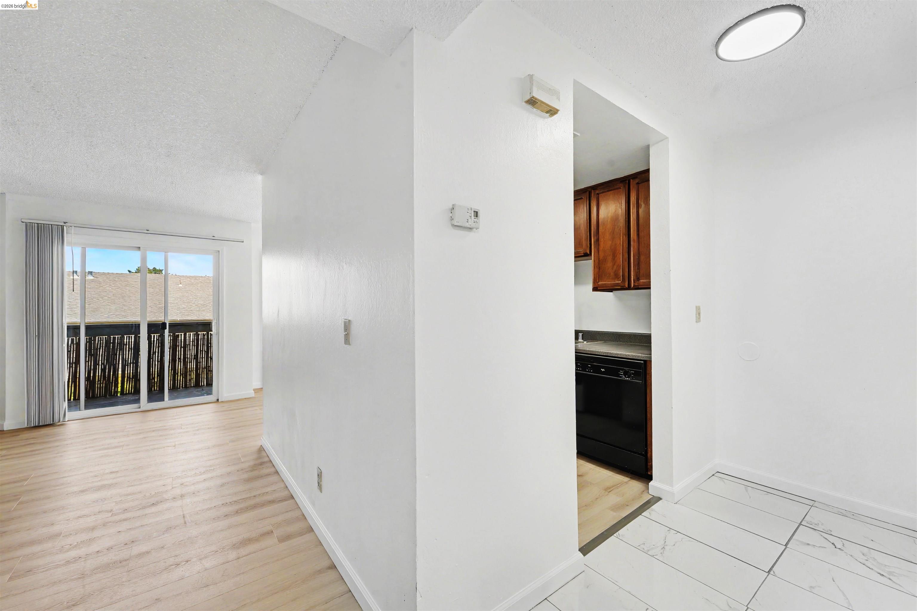 4186 San Pablo Dam Road, Unit A El Sobrante, CA 94803 - Photo 26 of 34 Bright interior featuring light wood-finish flooring, white walls, and a sliding glass door opening to an exterior balcony