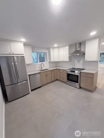 a large kitchen with white cabinets and stainless steel appliances