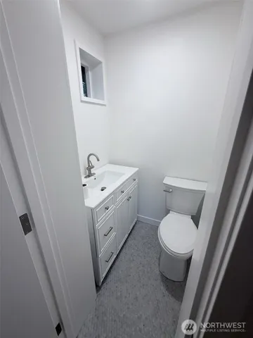a white toilet sitting next to a white sink and vanity