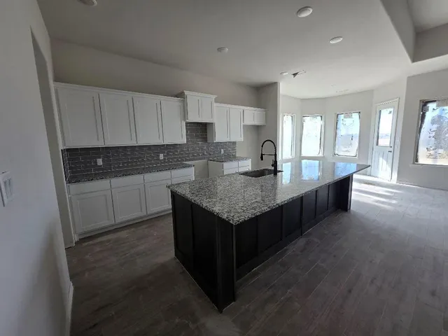 a kitchen with granite countertop sink and cabinets