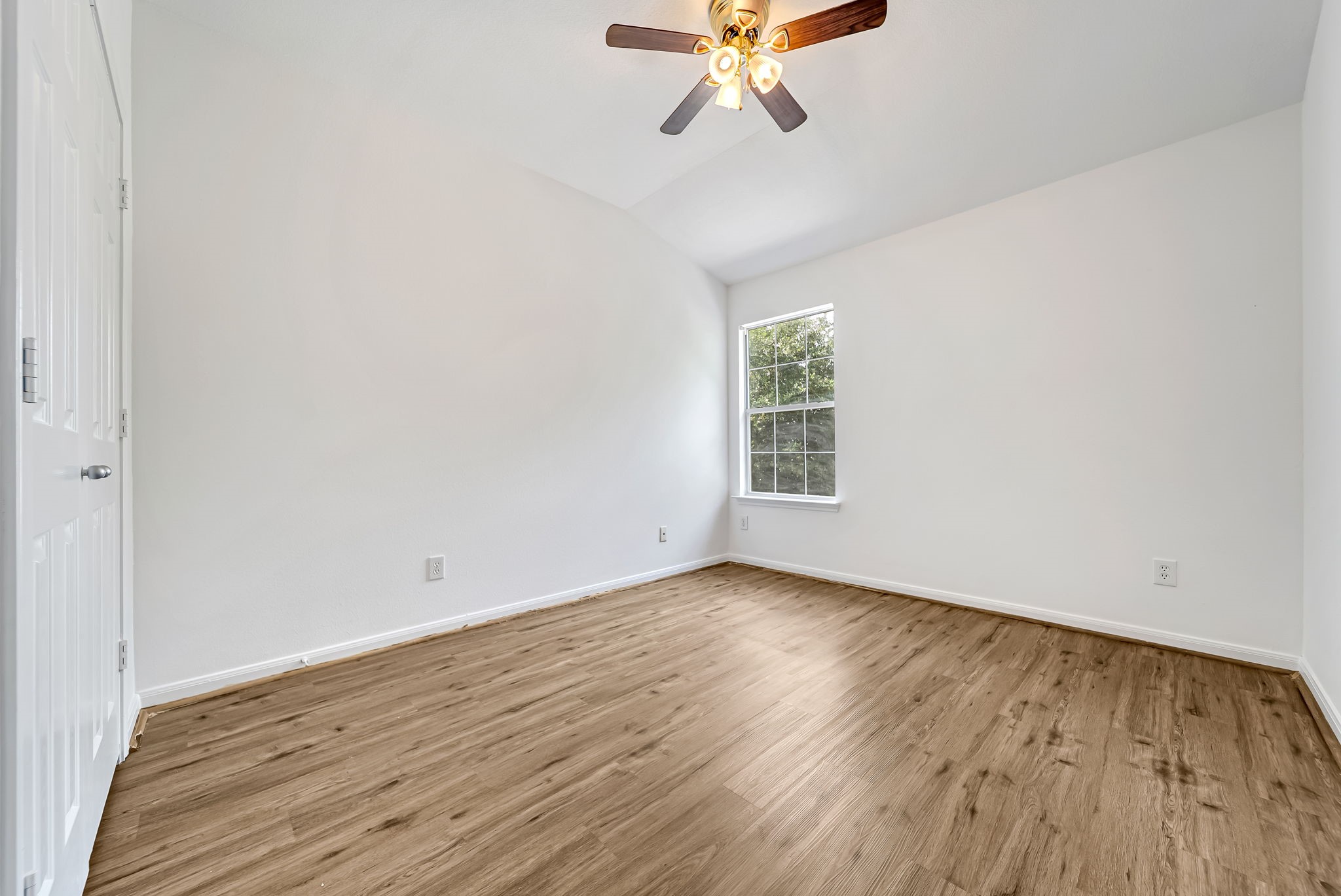 23526 Whispering Maple Drive Spring, TX 77373 - Photo 18 of 26 an empty room with wooden floor fan and windows