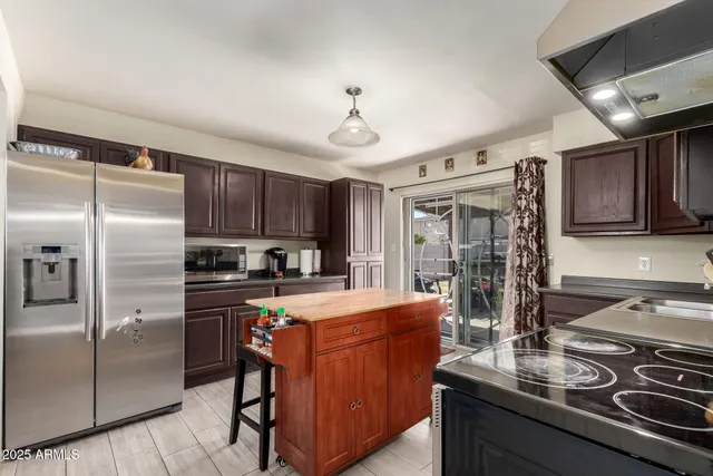 a kitchen with stainless steel appliances a sink stove refrigerator and cabinets