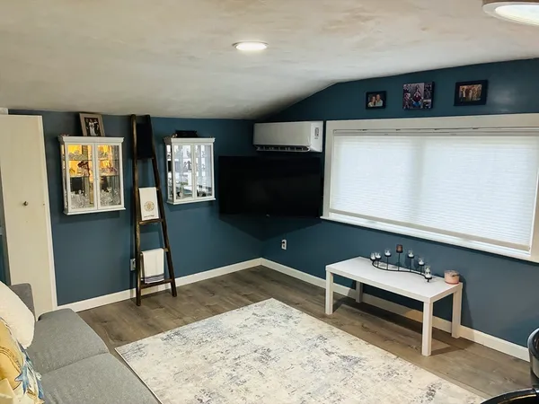 a living room with furniture a rug and a wooden floor