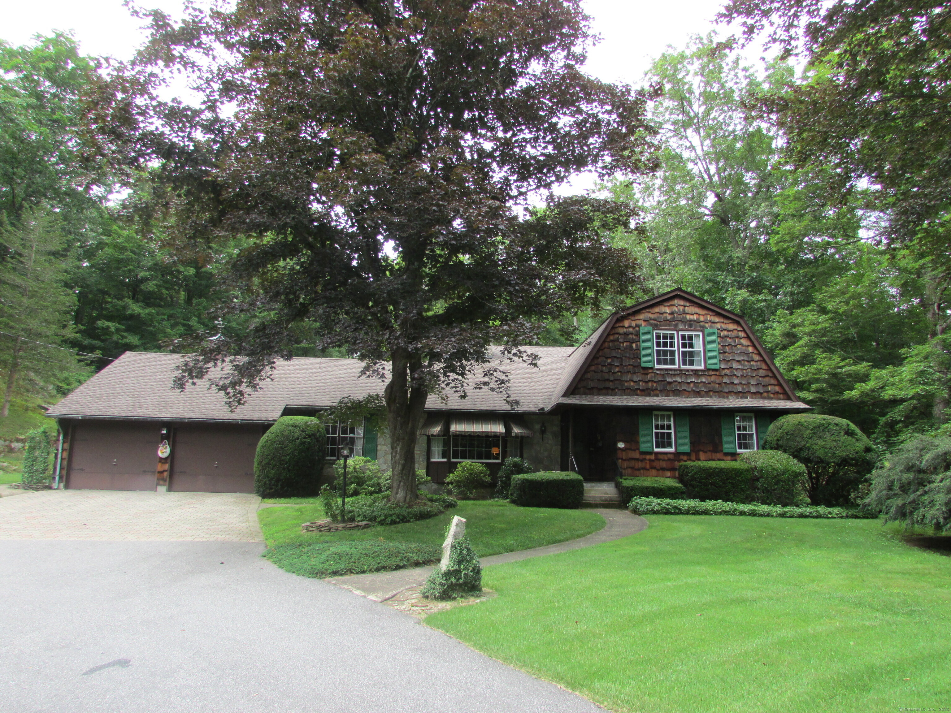 a front view of a house with a yard garage and trees