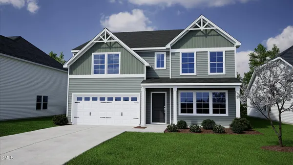 a front view of a house with a yard and green space