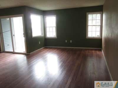 819 Edpas Road New Brunswick, NJ 08901 - Photo 2 of 6 an empty room with wooden floor and windows