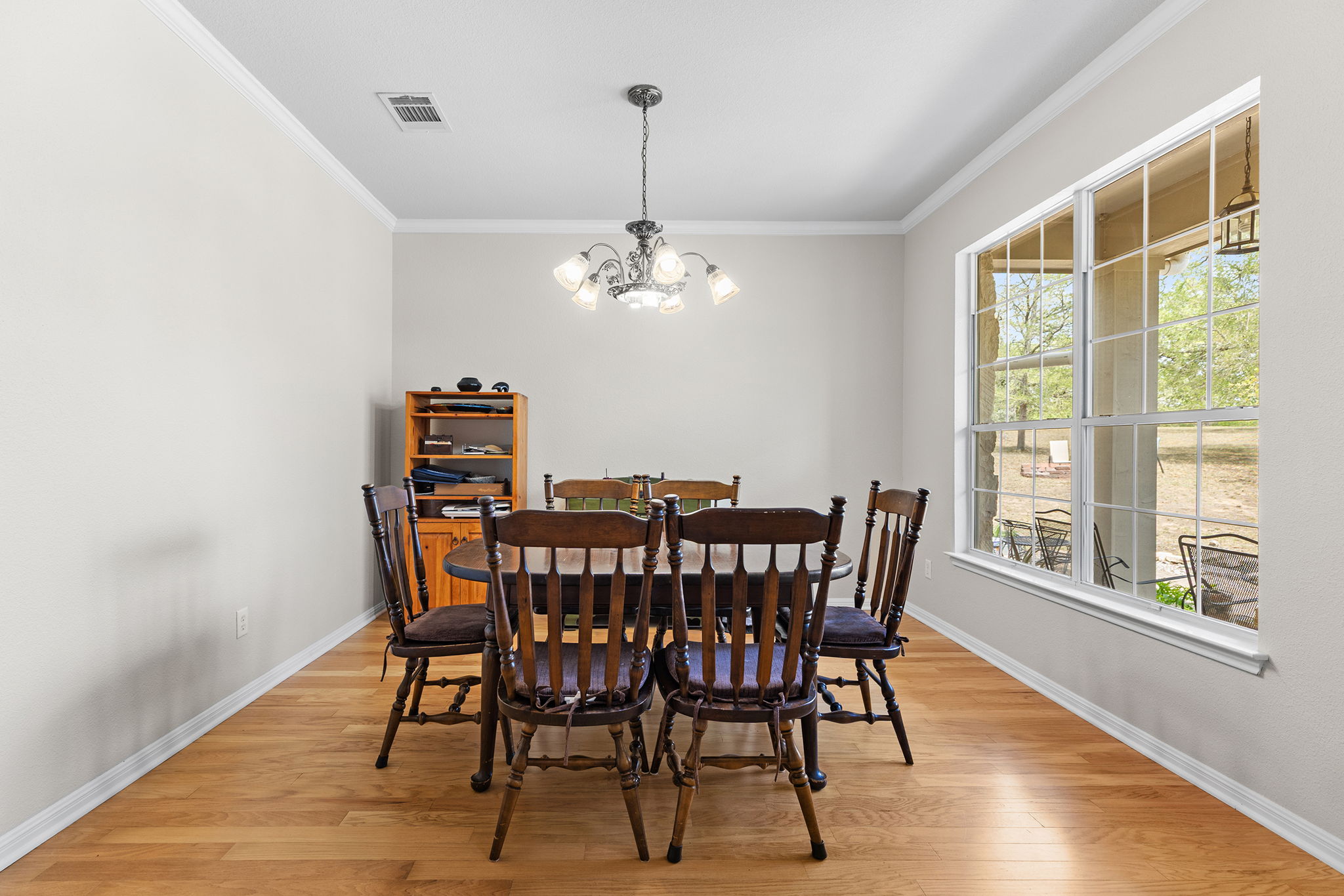 202 The Oaks Boulevard Elgin, TX 78621 - Photo 15 of 40 Dining space with suspended lighting, light wood-type flooring, and crown molding