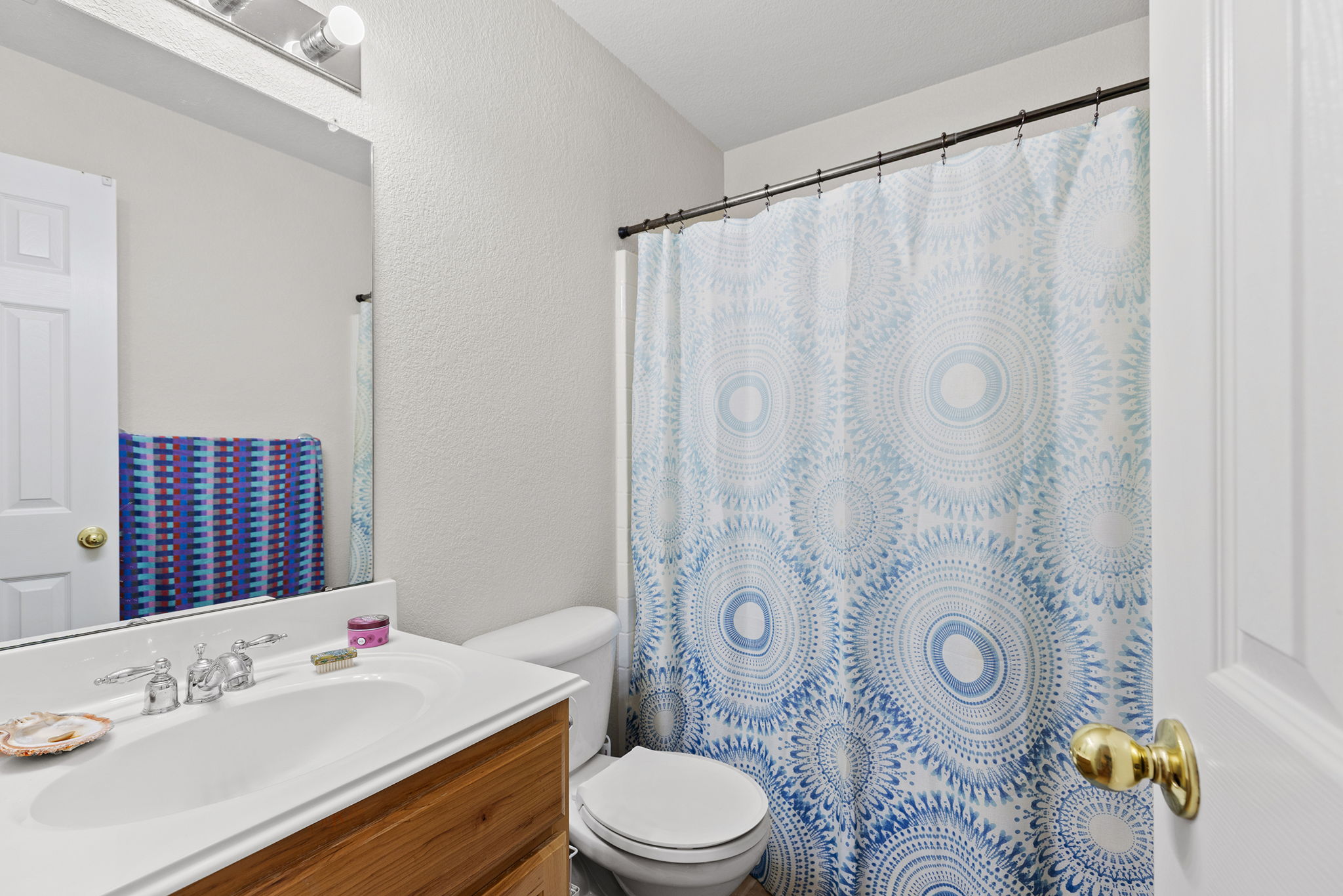 202 The Oaks Boulevard Elgin, TX 78621 - Photo 28 of 40 Full bathroom featuring vanity, a textured wall, and curtained shower