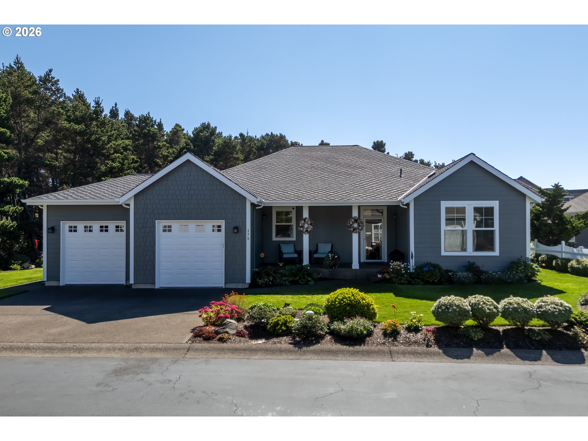 175 Southwest 59th Street South Beach, OR 97366 - Photo 1 of 48 a front view of a house with a garden and porch