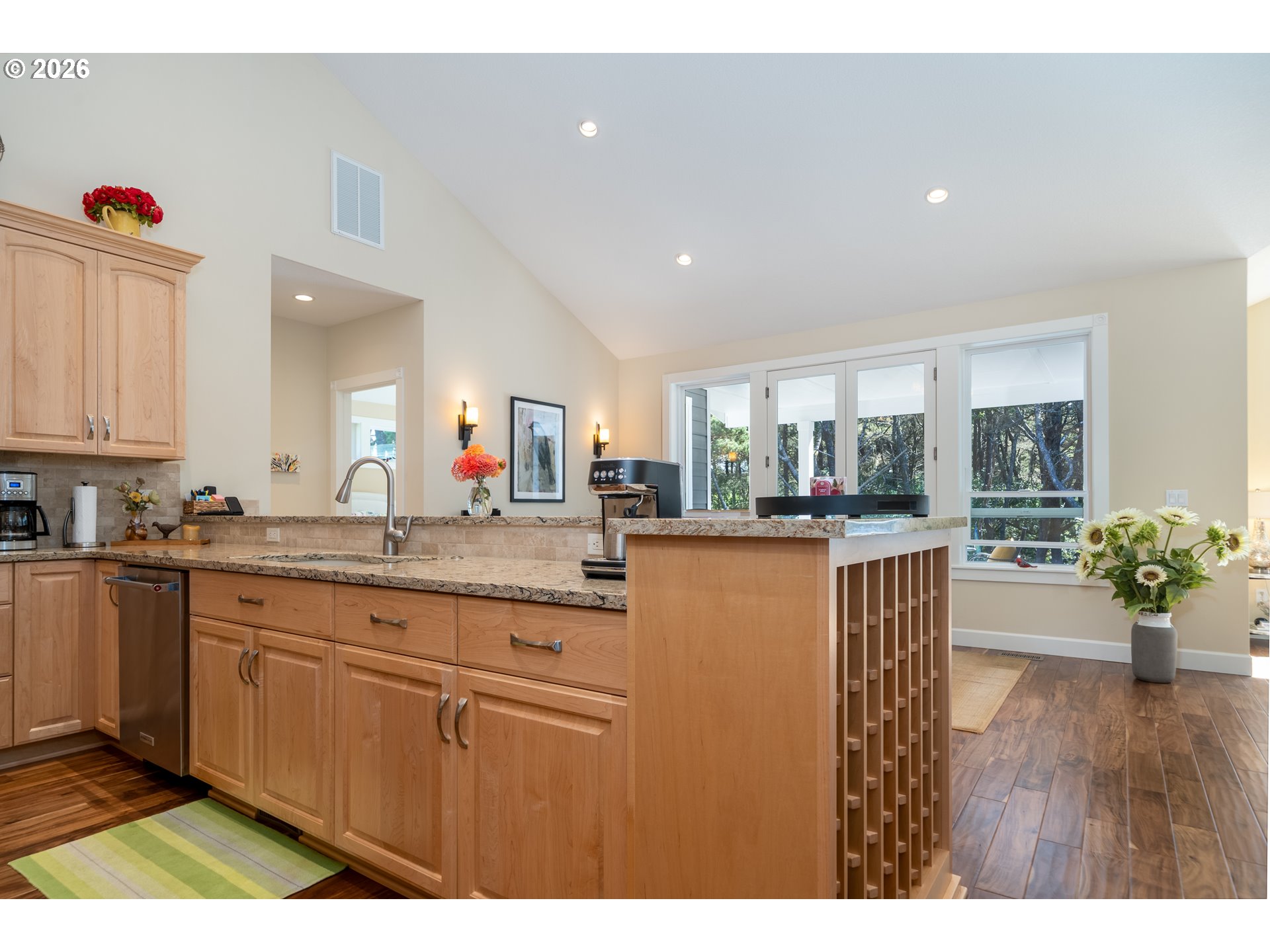 175 Southwest 59th Street South Beach, OR 97366 - Photo 25 of 48 a open kitchen with stainless steel appliances granite countertop a refrigerator a sink dishwasher and wooden cabinets with wooden floor