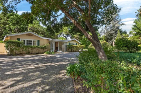 a front view of a house with a yard and green space