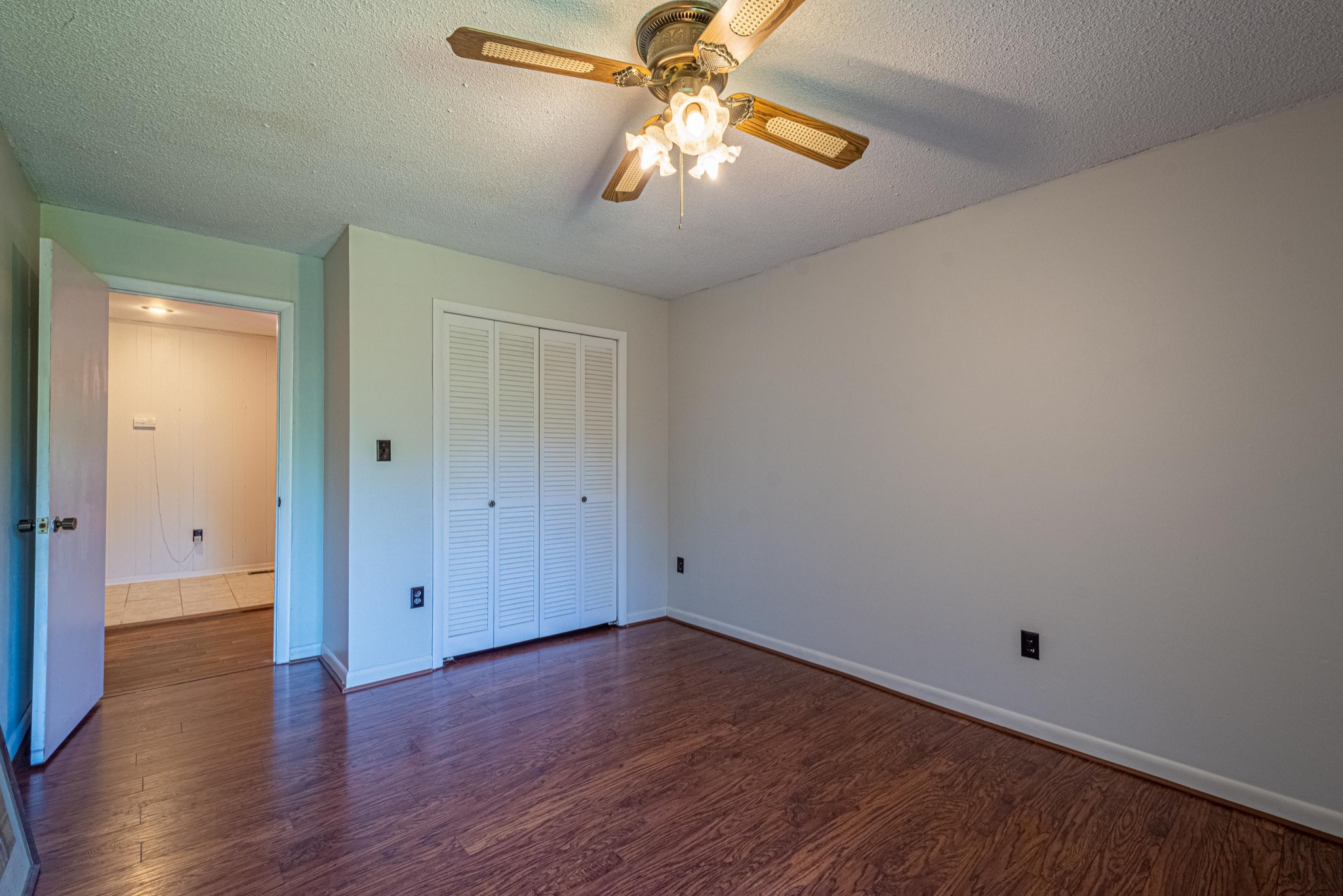 2842 Dog Branch Road Prospect, TN 38477 - Photo 24 of 50 an empty room with wooden floor chandelier fan and windows