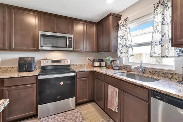 a kitchen with a sink stove top oven and wooden cabinets