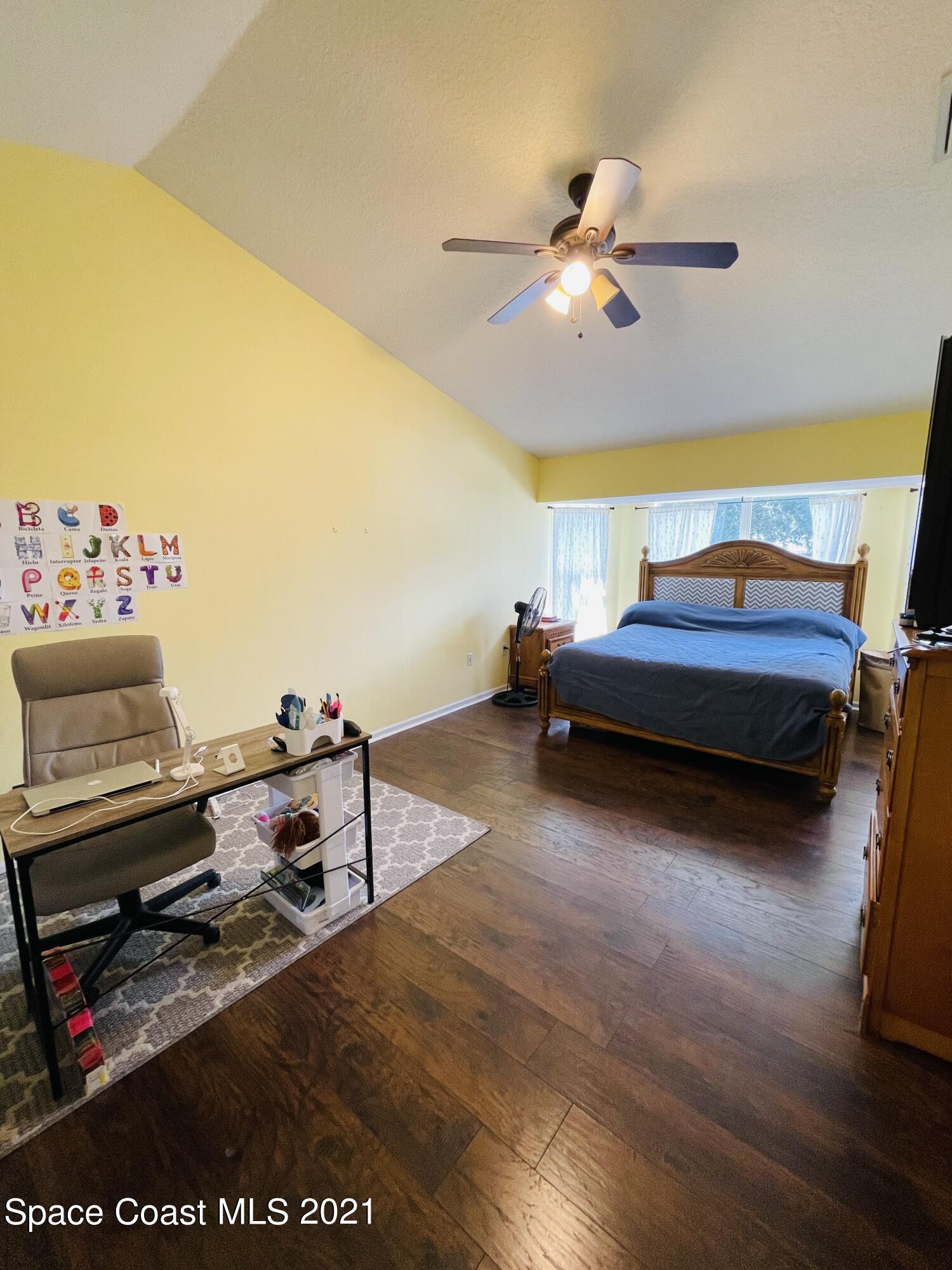 2374 Angel Road Palm Bay, FL 32909 - Photo 14 of 19 a bedroom with a bed and a chandelier
