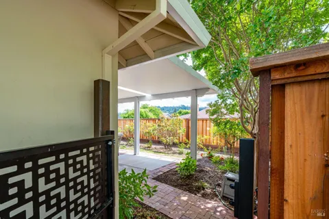 a backyard of a house with table and chairs under an umbrella