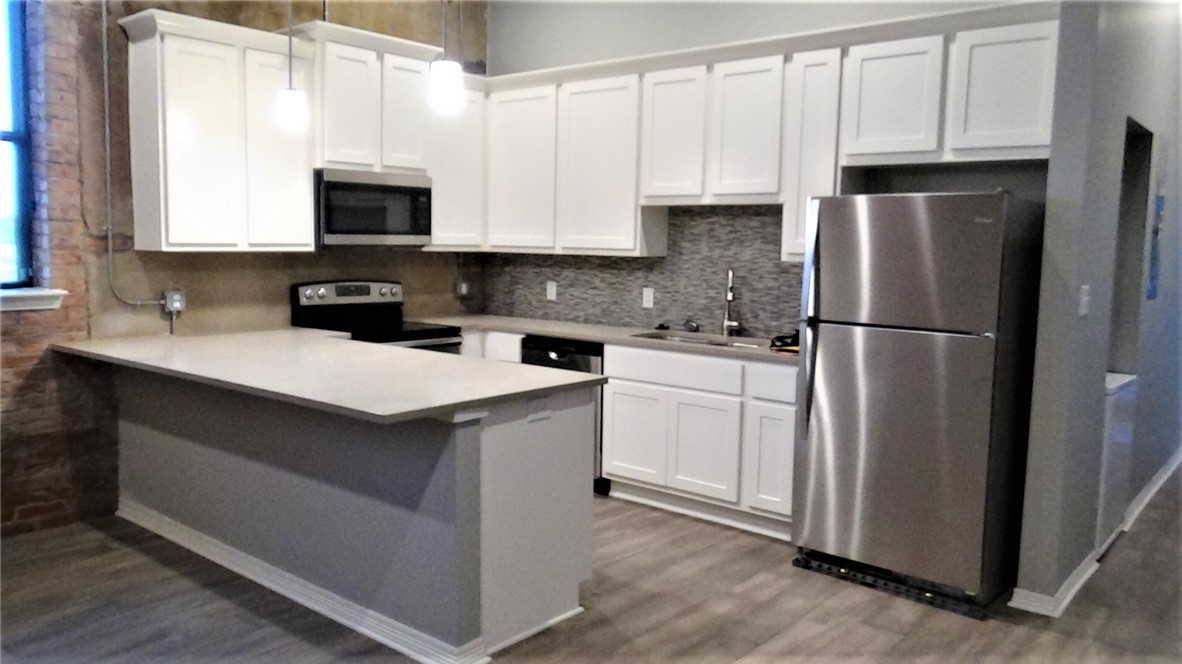a kitchen with white cabinets sink and stainless steel appliances
