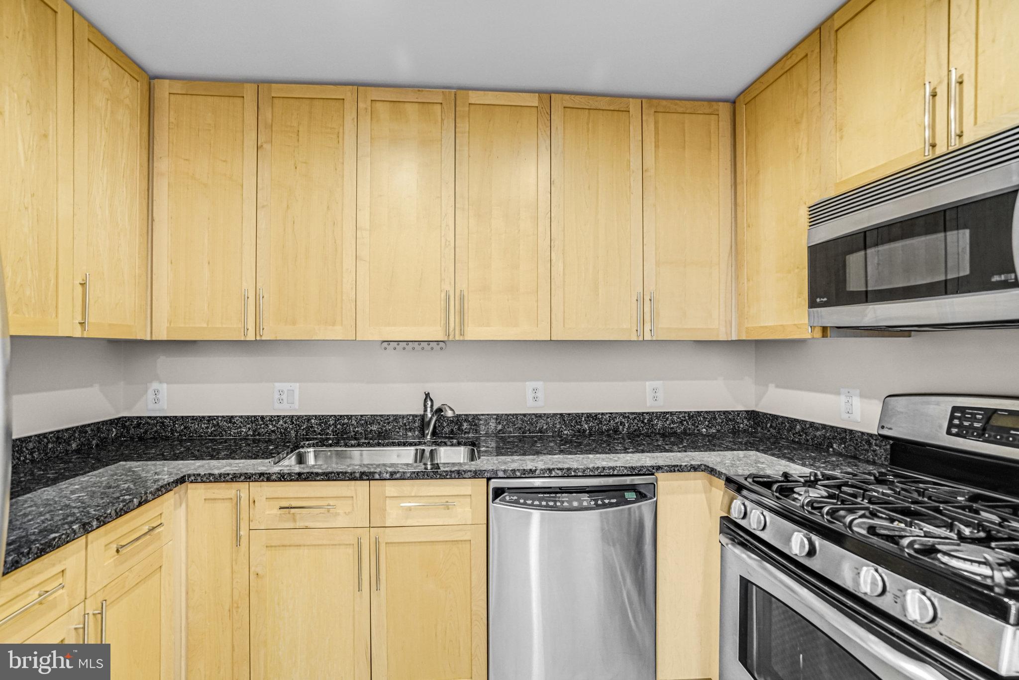 820 North Pollard Street, Unit 915 Arlington, VA 22203 - Photo 14 of 30 a kitchen with stainless steel appliances granite countertop a stove a sink and dishwasher with white cabinets