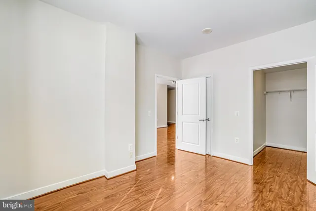 a view of empty room with wooden floor