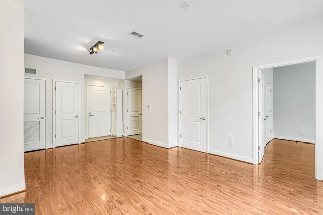 a view of an empty room with wooden floor