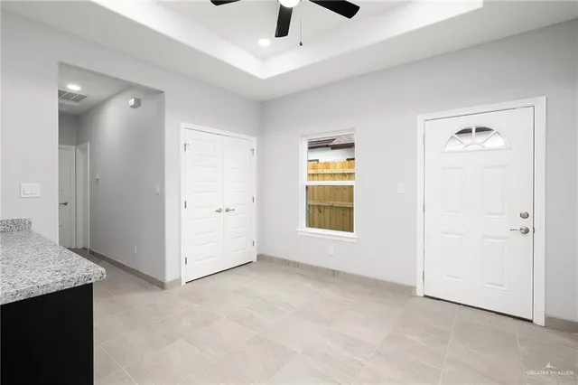 an empty room with windows and ceiling fan