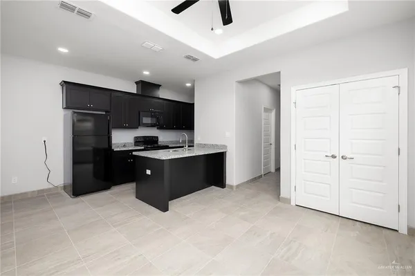 a kitchen with stainless steel appliances kitchen island granite countertop a refrigerator and a stove top oven