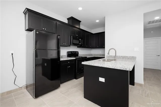 a kitchen with a sink stainless steel appliances a refrigerator and cabinets
