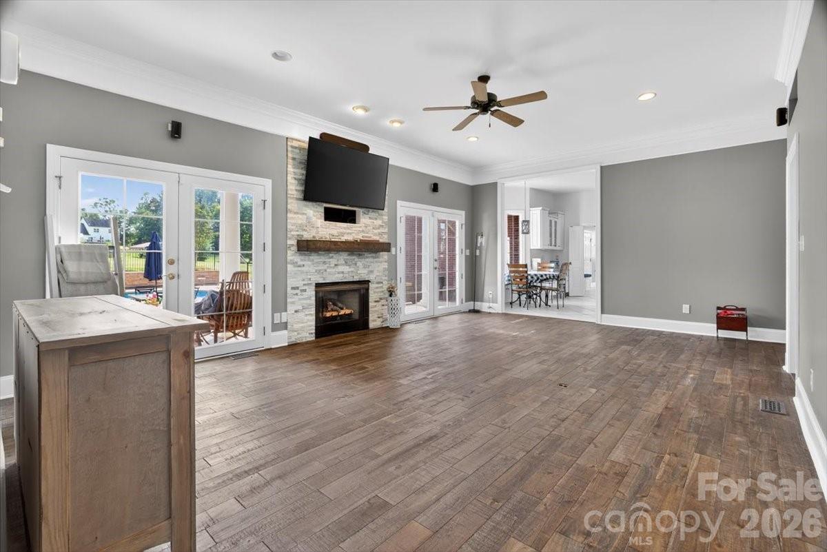 498 Johnson Dairy Road Mooresville, NC 28115 - Photo 19 of 43 a view of a livingroom with a fireplace a ceiling fan and wooden floor