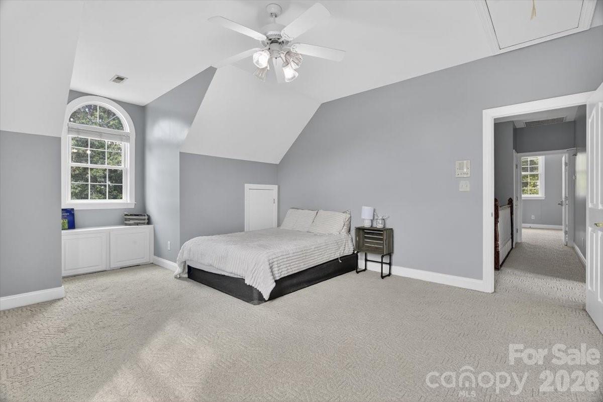 498 Johnson Dairy Road Mooresville, NC 28115 - Photo 28 of 43 a spacious bedroom with a bed and a chandelier