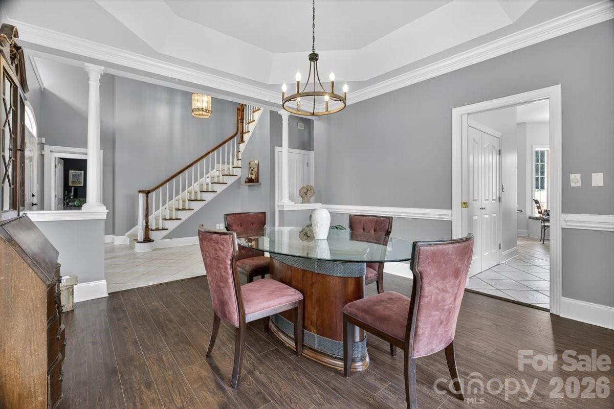 498 Johnson Dairy Road Mooresville, NC 28115 - Photo 8 of 43 a dining room with wooden floor a chandelier a wooden table and chairs