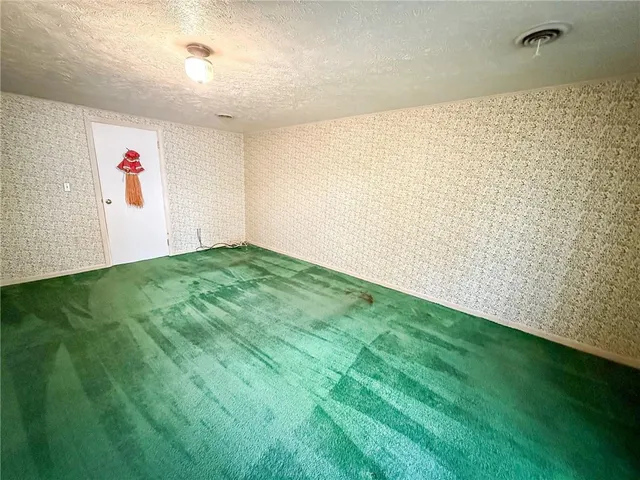 a view of an empty room with closet and stairs