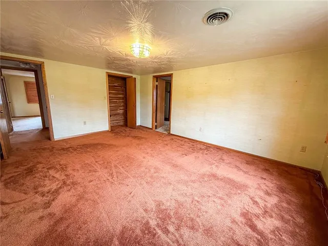 a room with a bed and a wooden floor