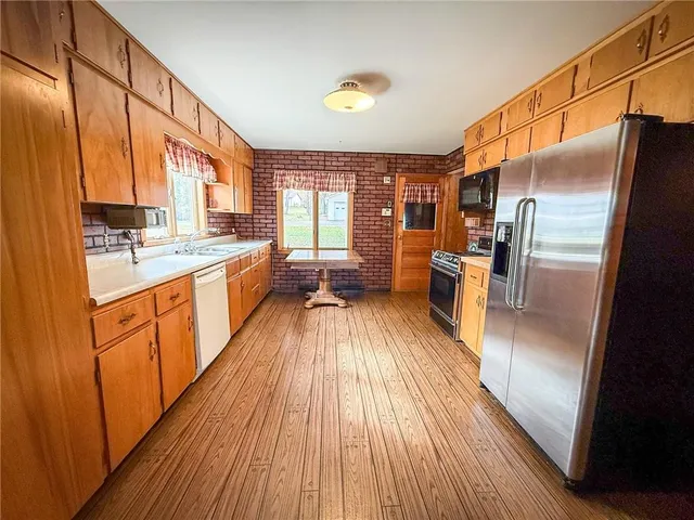 a large kitchen with a lot of counter space and a wooden floor