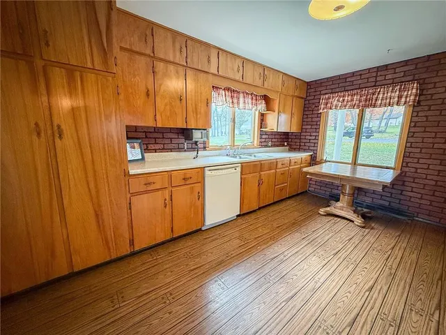 a kitchen with granite countertop wooden floors and stainless steel appliances