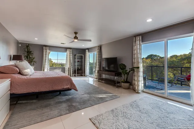 a spacious bedroom with a bed and a flat screen television