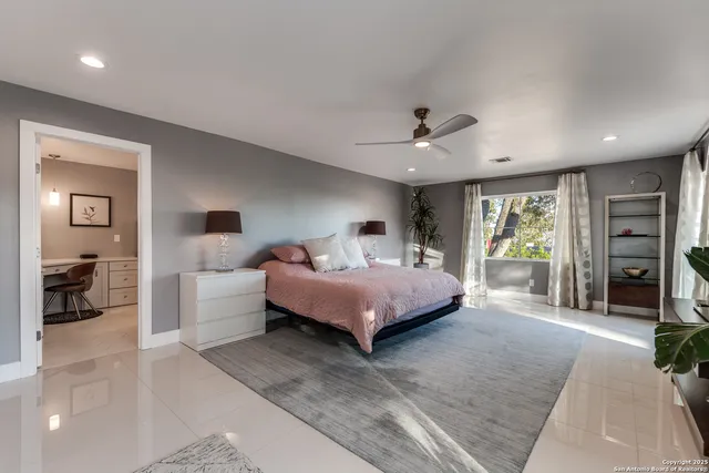 a spacious bedroom with a bed a couch and a chandelier