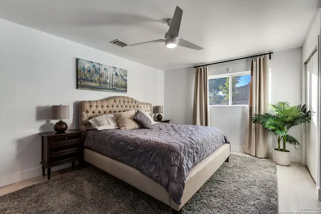 a bedroom with a large bed and a chandelier