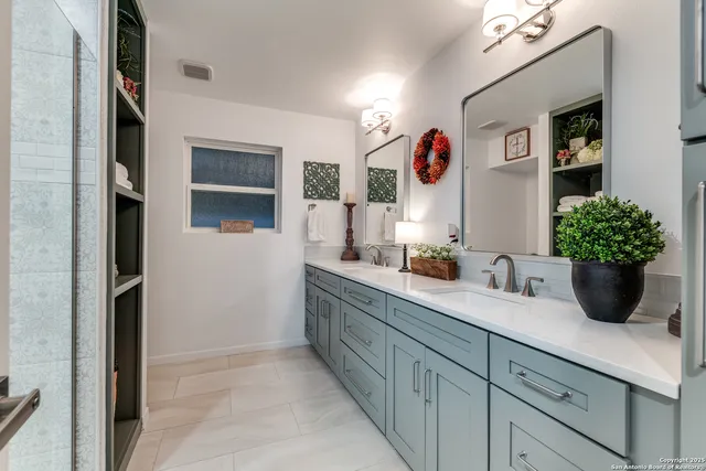 a bathroom with a double vanity sink mirror and shower
