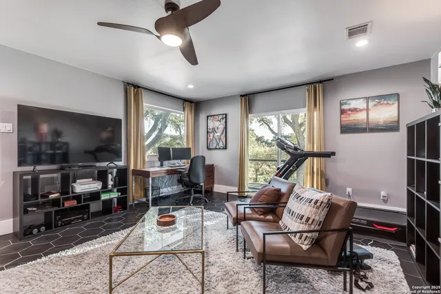 a living room with furniture a flat screen tv and a large window