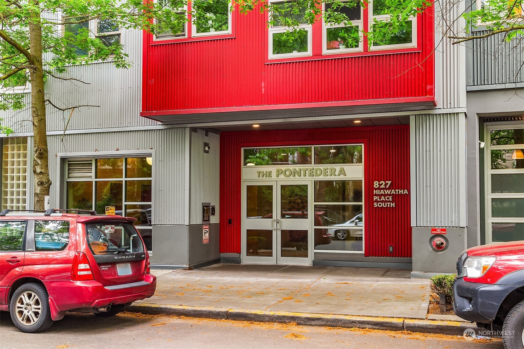 a view of a red car is parked in front of a building