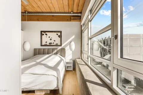 a view of a bedroom with wooden floor and windows