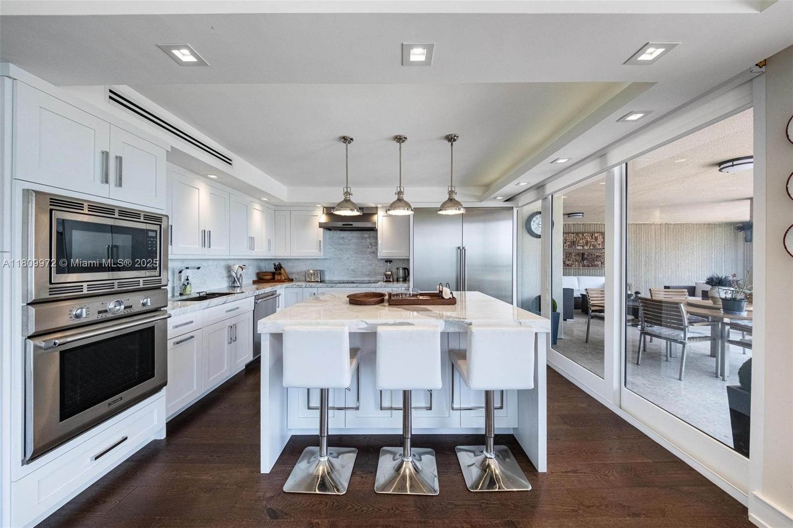 2901 South Bayshore Drive, Unit 17G/H Miami, FL 33133 - Photo 12 of 81 a large kitchen with a table and chairs in it