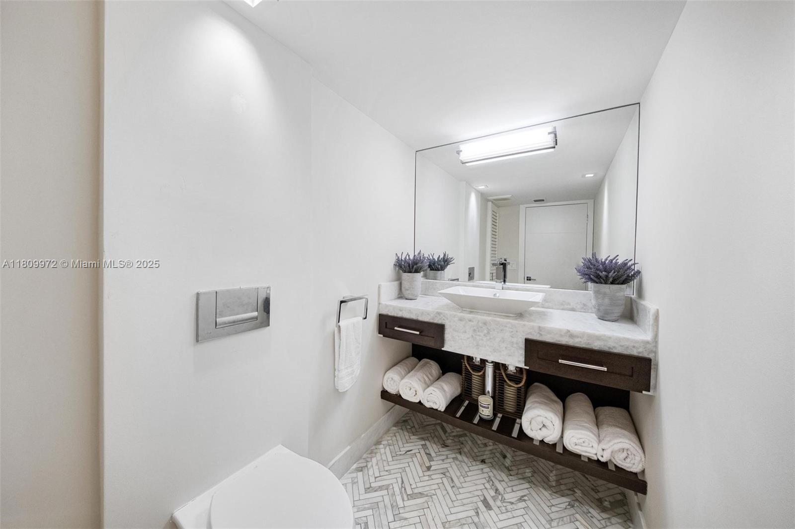 2901 South Bayshore Drive, Unit 17G/H Miami, FL 33133 - Photo 29 of 81 a bathroom with a toilet a sink and mirror