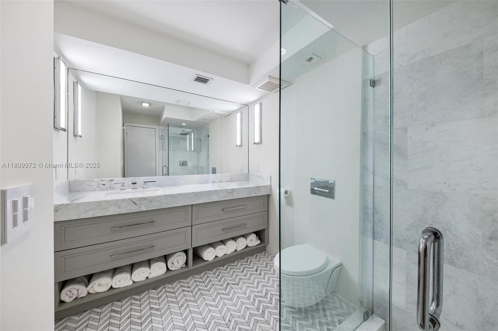 2901 South Bayshore Drive, Unit 17G/H Miami, FL 33133 - Photo 31 of 81 a bathroom with a granite countertop sink toilet a shower and a mirror