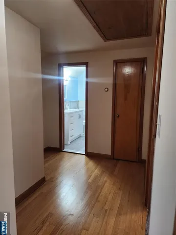 an empty room with wooden floor & closet area