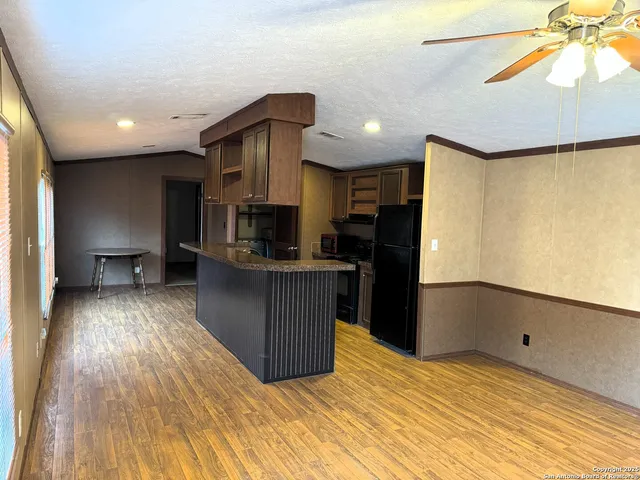 a kitchen with stainless steel appliances kitchen island granite countertop a refrigerator and a stove top oven