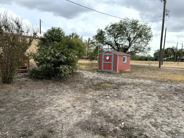 a sign that is sitting in front of a tree